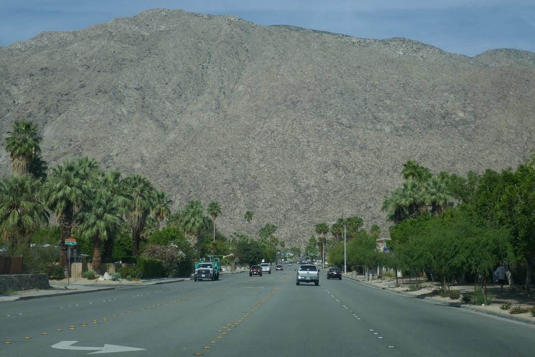 A palm-lined Palm Springs street beneath the San Jacinto Mountains