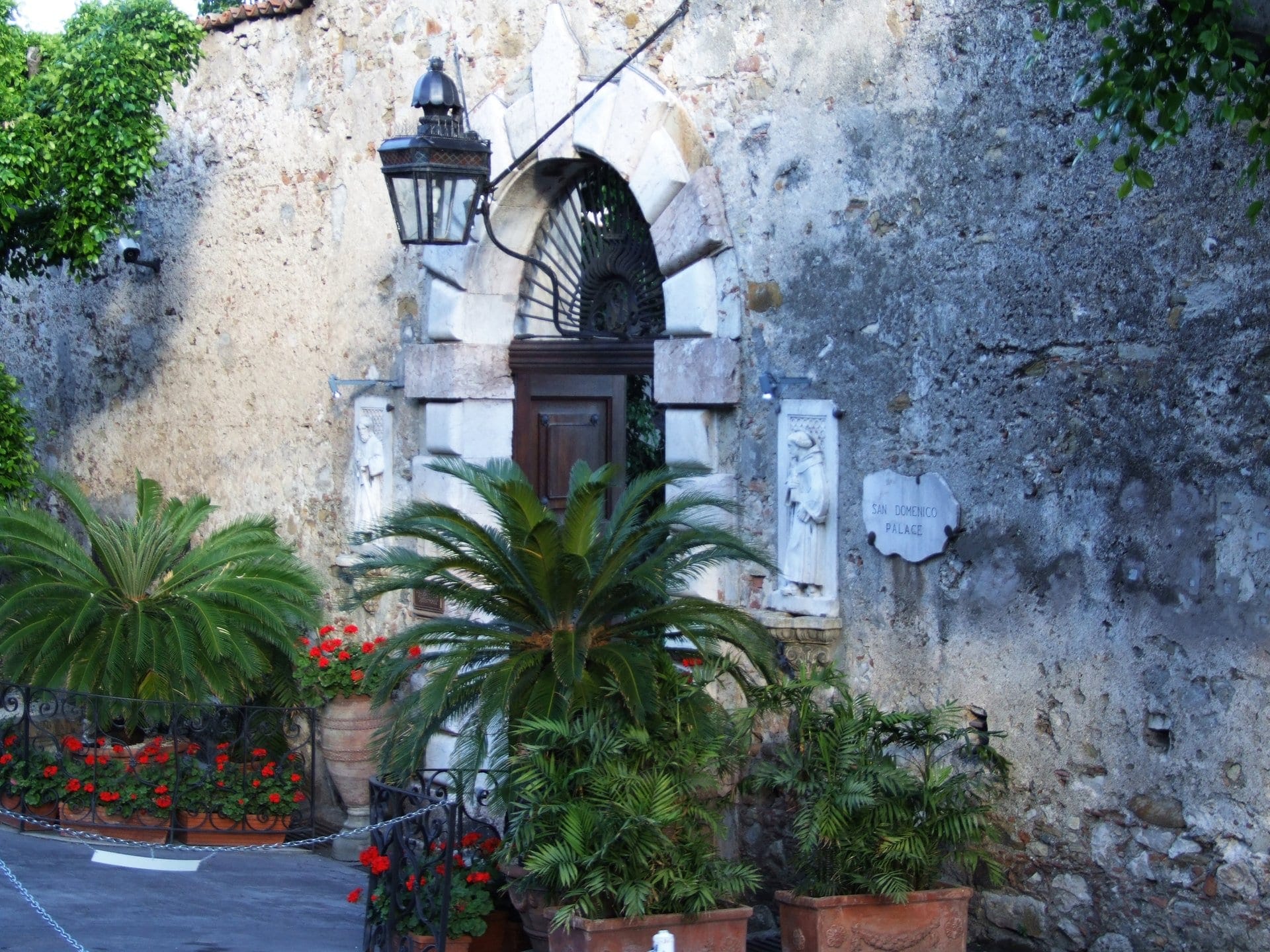 The San Domenico Palace hotel in Taormina, Sicily, framed by bougainvillea with Mount Etna beyond